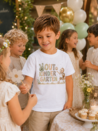 Junge trägt weißes Kinder-T-Shirt mit Out Kindergarten Motiv und spielt bei einer liebevoll dekorierten Kindergartenabschlussfeier mit anderen Kindern