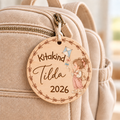 Bunter Kita-Anhänger aus Holz mit Blumenrand, Mädchen mit Flugdrachen und Beispielname Tilda am Rucksack