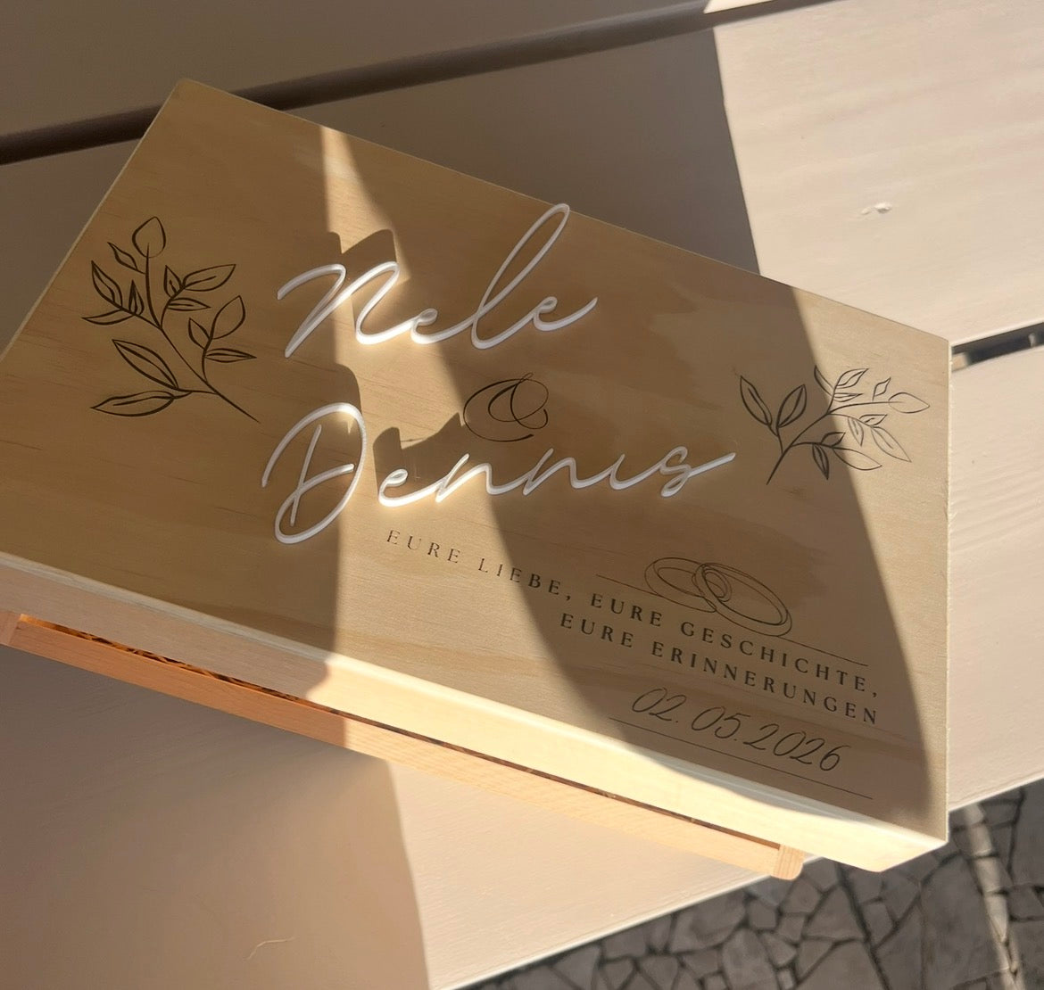 Personalisierte Hochzeitsbox aus Holz in schräger Ansicht mit weißen erhabenen Namen und feiner Gravur.
