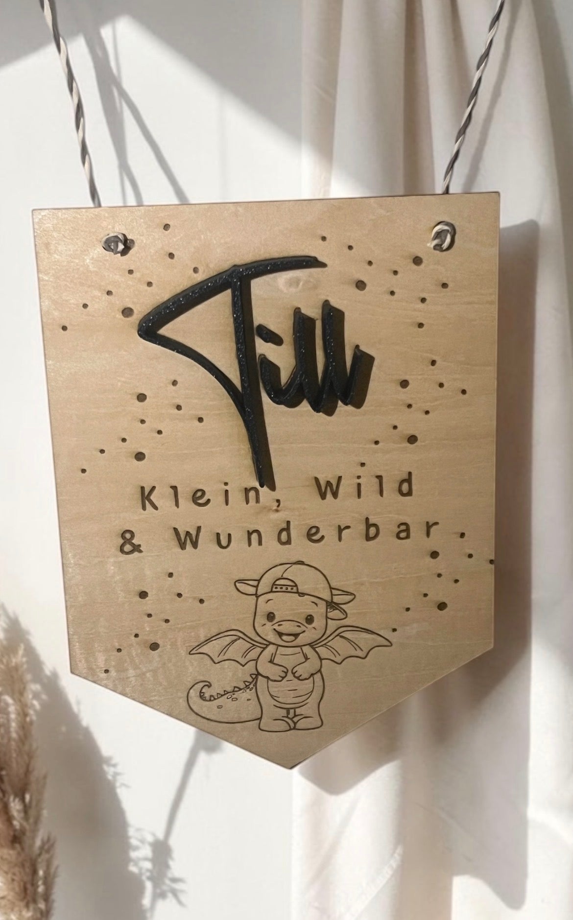 Holzwimpel fürs Kinderzimmer mit dunklem erhabenem Namen, Drachenmotiv und dem Text Klein, wild und wunderbar.