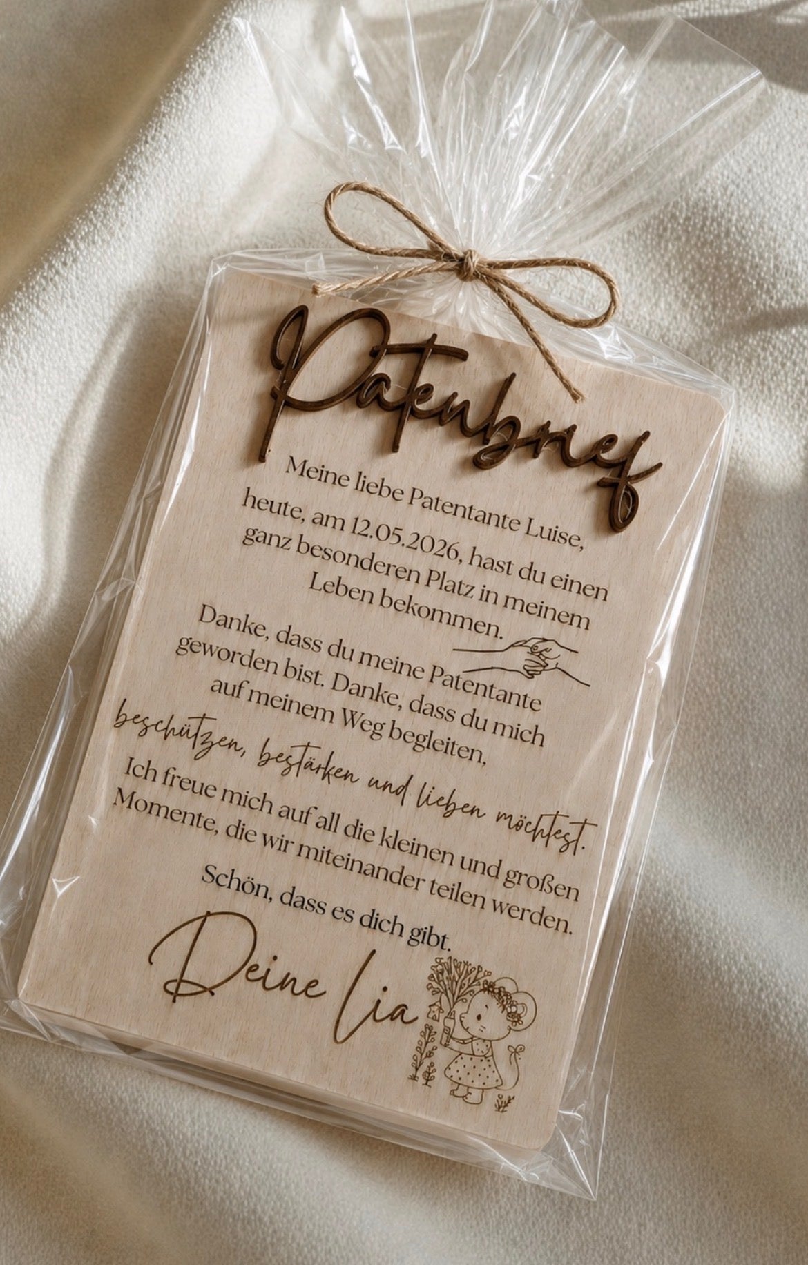 Holzkarte für eine Patentante mit graviertem Dankestext, dunklem Schriftzug und Juteschleife in transparenter Verpackung.